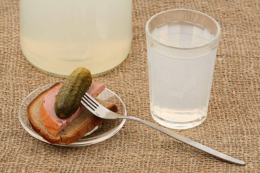 мутный самогон в стакане и закуска